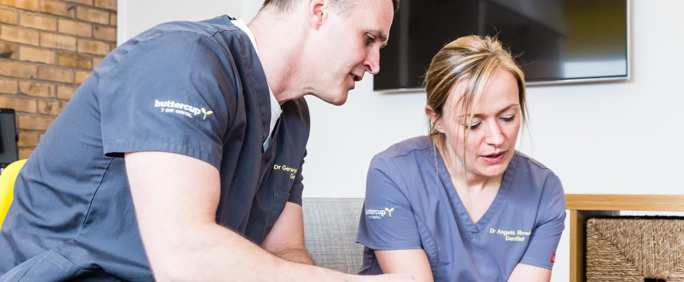 A Buttercup dentist talking a patient through their treatment